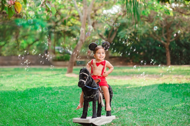enfant assis sur un cheval à bascule